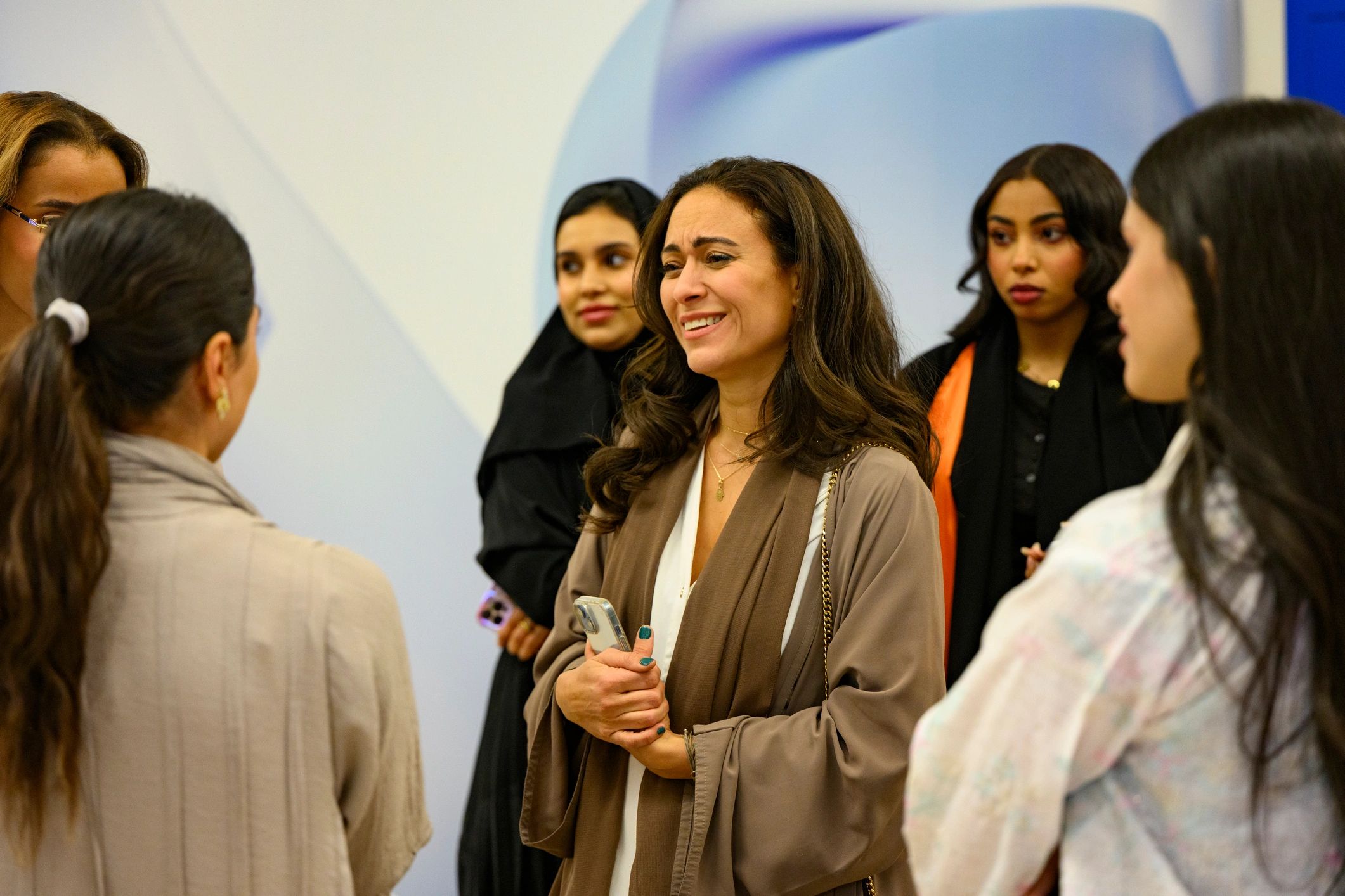 Saudi women in a modern lifestyle setting, smiling and talking together